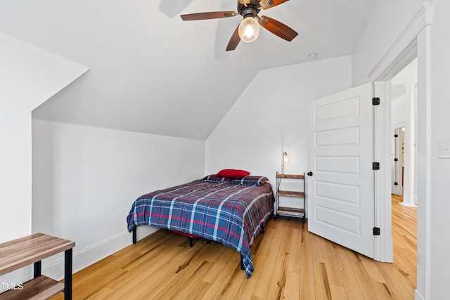 bedroom featuring lofted ceiling, light wood finished floors, baseboards, and a ceiling fan