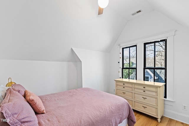 bedroom featuring light wood-type flooring, visible vents, ceiling fan, and lofted ceiling