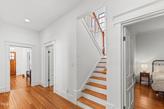 stairway featuring hardwood / wood-style flooring, baseboards, and recessed lighting