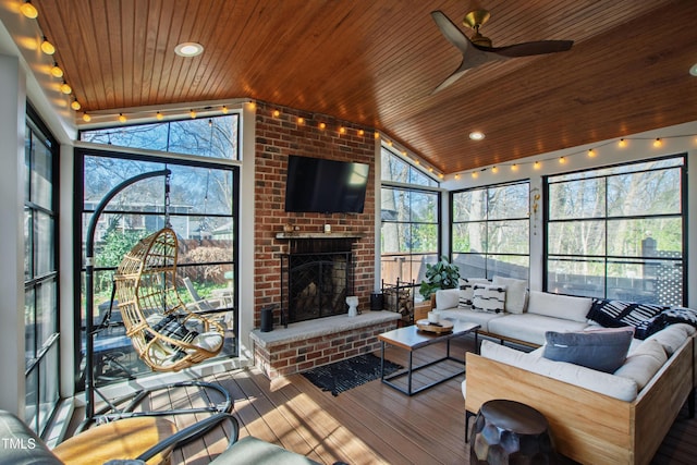 sunroom with a brick fireplace, wooden ceiling, and vaulted ceiling