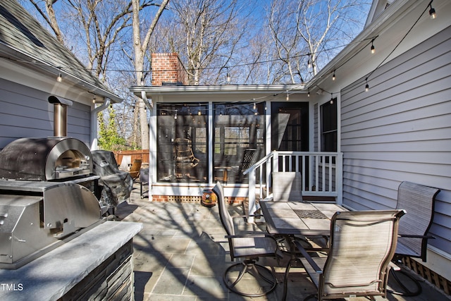 deck featuring a patio, outdoor dining area, an outdoor kitchen, area for grilling, and a sunroom