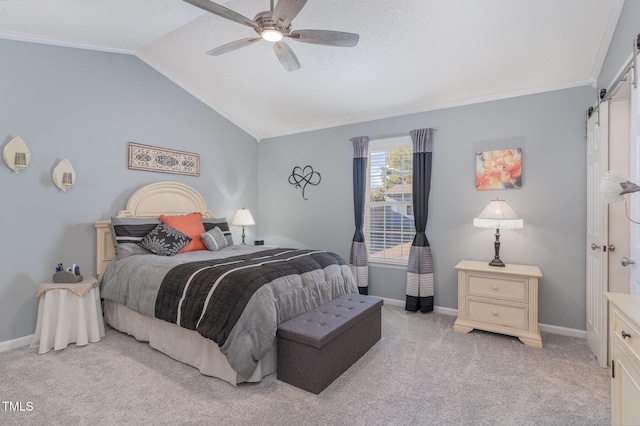 carpeted bedroom featuring ceiling fan, ornamental molding, a textured ceiling, vaulted ceiling, and a barn door