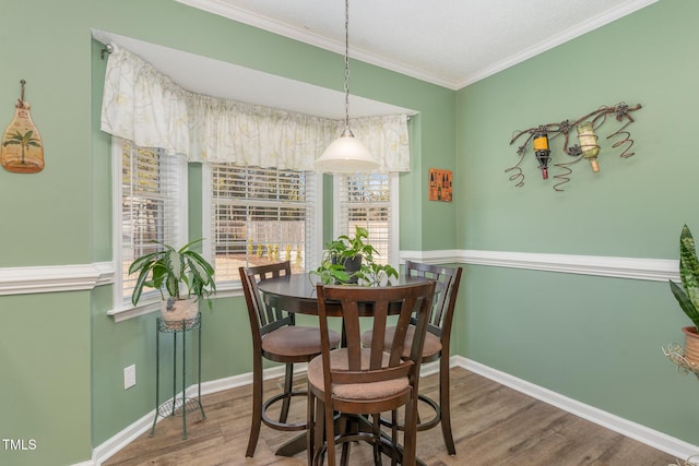 dining area featuring wood-type flooring and crown molding