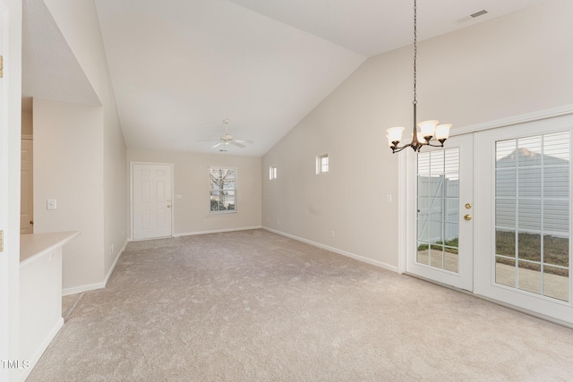 unfurnished living room with light carpet, ceiling fan with notable chandelier, and high vaulted ceiling