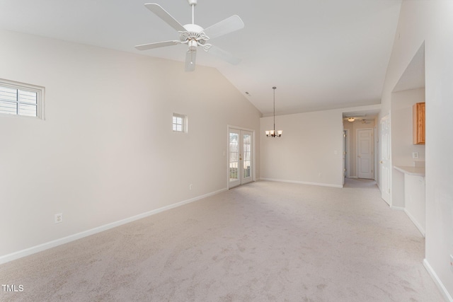 carpeted spare room featuring lofted ceiling, ceiling fan, and french doors