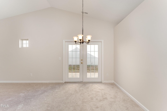 unfurnished room featuring a healthy amount of sunlight, light carpet, and a notable chandelier