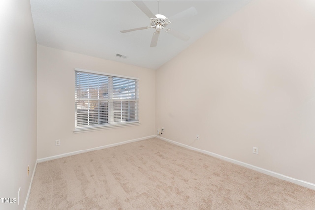 carpeted spare room featuring vaulted ceiling and ceiling fan