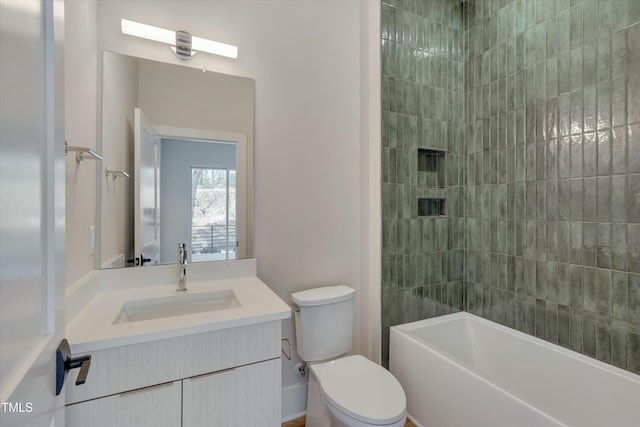 full bathroom featuring tiled shower / bath, vanity, and toilet