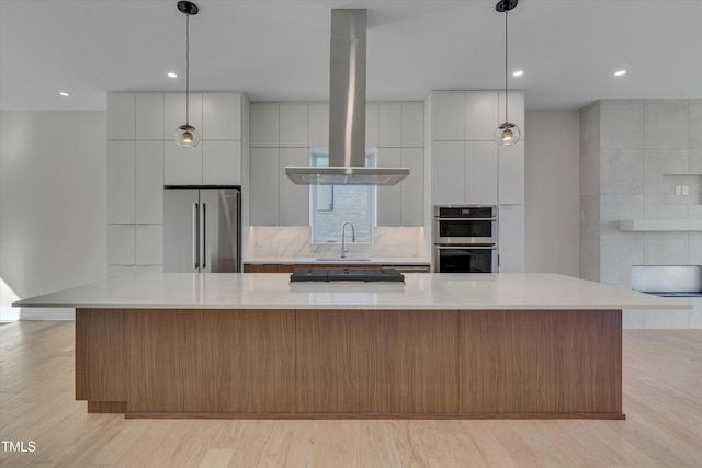 kitchen featuring white cabinetry, appliances with stainless steel finishes, a large island, and decorative light fixtures