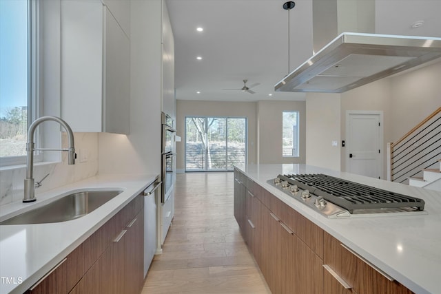 kitchen with stainless steel appliances, hanging light fixtures, sink, and white cabinets