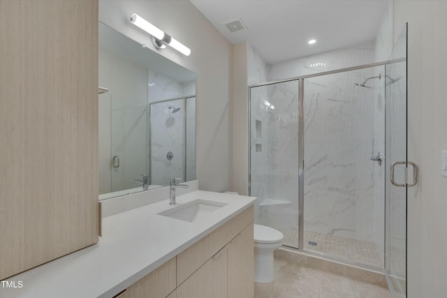 bathroom with vanity, toilet, and a shower with shower door