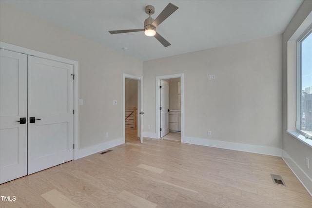 unfurnished bedroom with multiple windows, a closet, ceiling fan, and light wood-type flooring