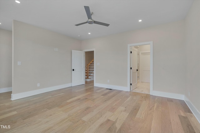 unfurnished bedroom with ceiling fan, a walk in closet, and light hardwood / wood-style floors