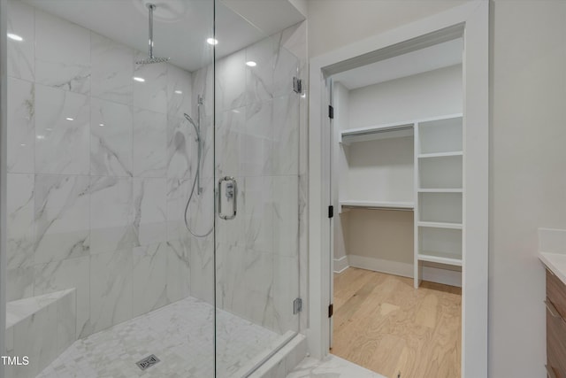 bathroom featuring hardwood / wood-style flooring, vanity, and a shower with door