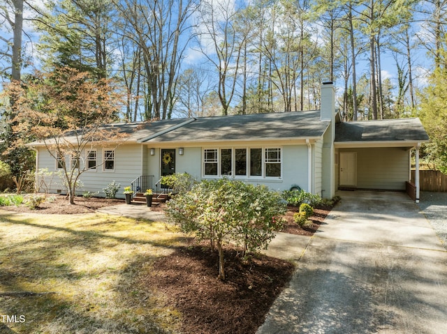 single story home featuring a carport, driveway, and a chimney