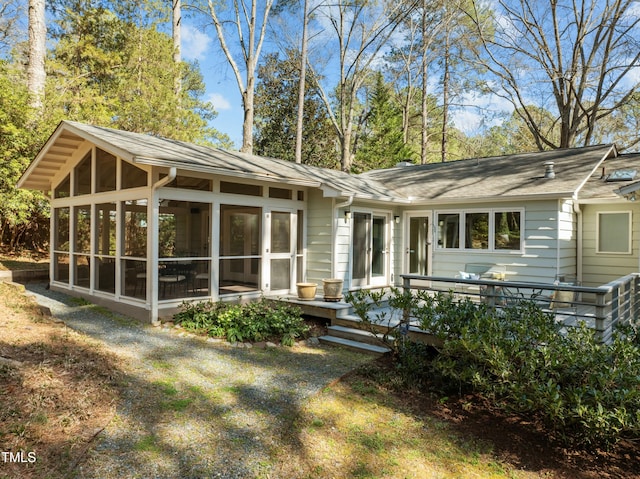 rear view of property featuring a sunroom