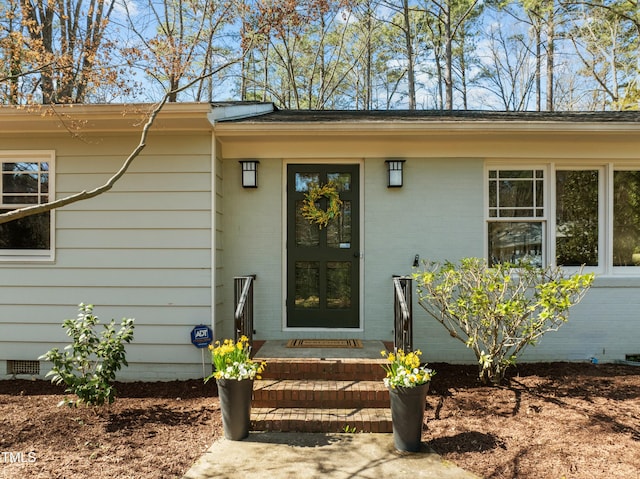 entrance to property with brick siding and crawl space