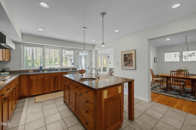 kitchen with a sink, brown cabinetry, and light tile patterned floors