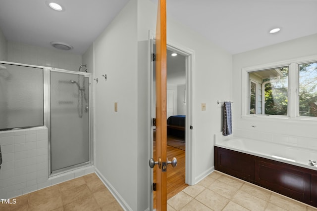 bathroom featuring connected bathroom, a garden tub, a shower stall, and tile patterned flooring