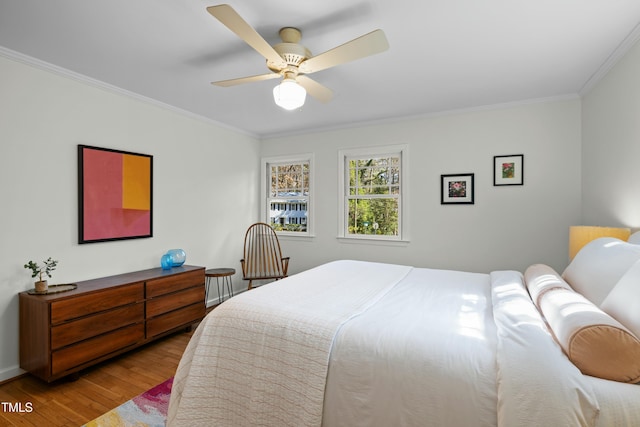 bedroom with ceiling fan, wood finished floors, and ornamental molding