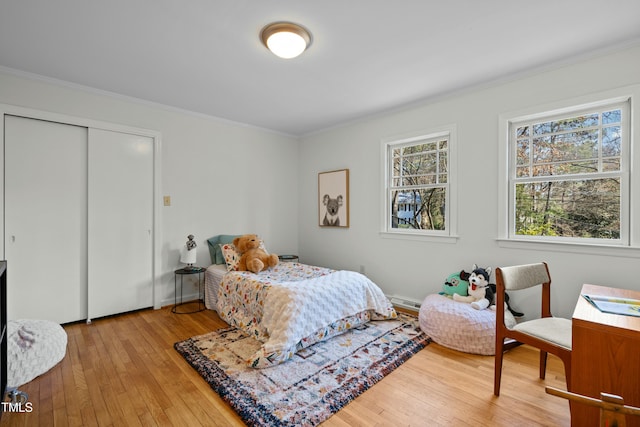 bedroom with a closet, crown molding, and hardwood / wood-style floors