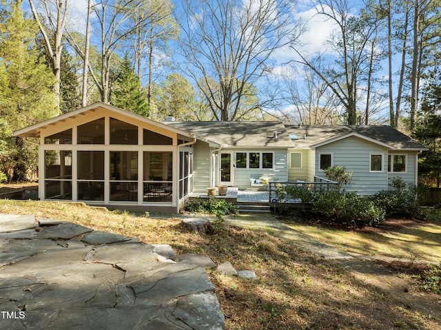 rear view of property with a deck and a sunroom