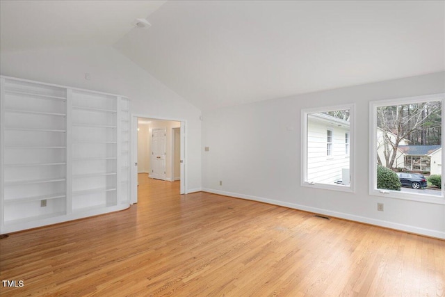 empty room with lofted ceiling and light hardwood / wood-style floors