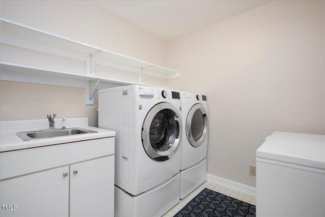 laundry area with cabinets, separate washer and dryer, sink, and light tile patterned floors