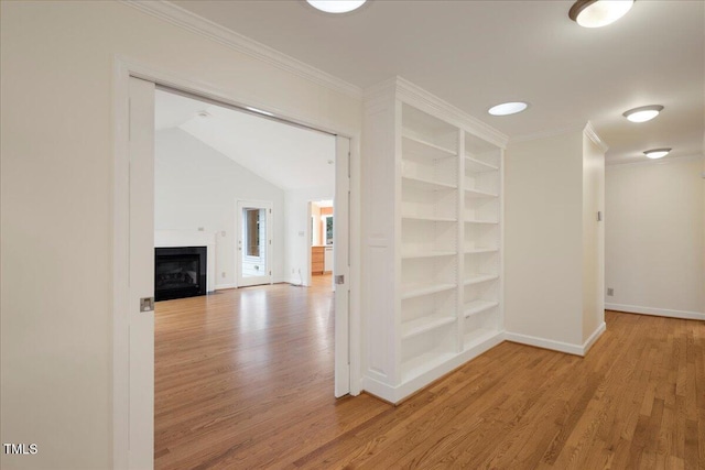 hallway featuring built in shelves, ornamental molding, and hardwood / wood-style floors