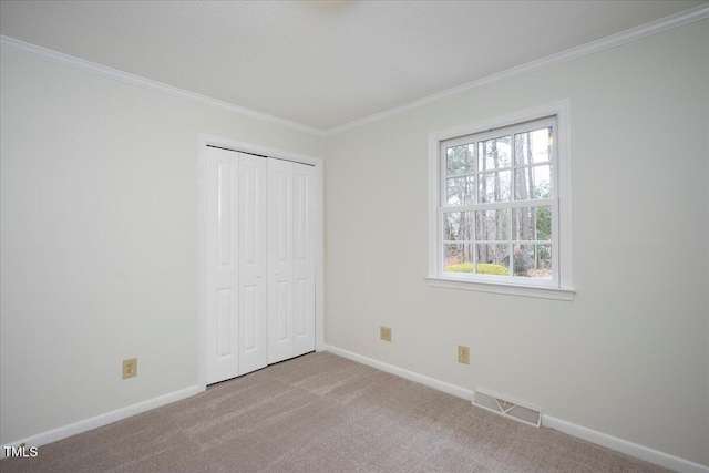 unfurnished bedroom featuring ornamental molding, light carpet, and a closet