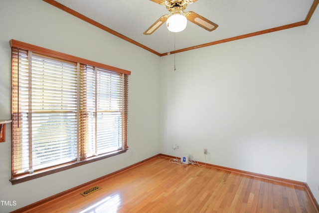 empty room featuring hardwood / wood-style flooring, crown molding, and ceiling fan