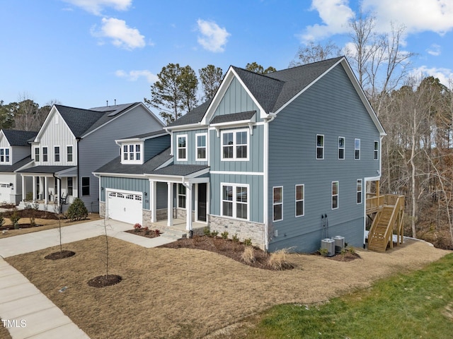 view of front facade featuring a garage, a front yard, central air condition unit, and covered porch