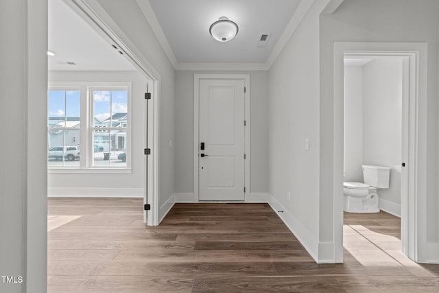 foyer entrance with hardwood / wood-style flooring and ornamental molding