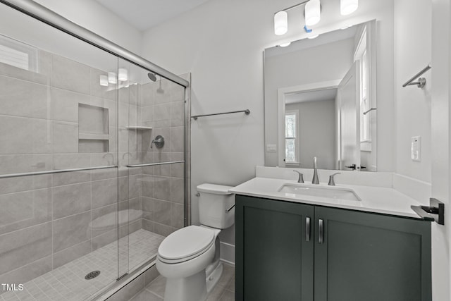 bathroom featuring vanity, toilet, and a shower with shower door