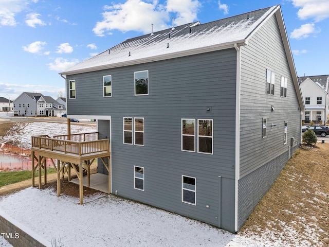 snow covered property with a deck