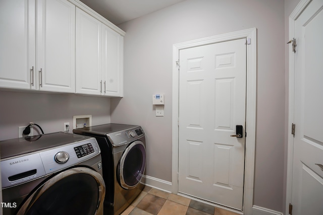 laundry area featuring cabinets, light tile patterned floors, and washing machine and clothes dryer