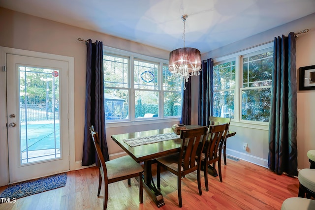 dining room featuring an inviting chandelier, a wealth of natural light, and light wood-type flooring