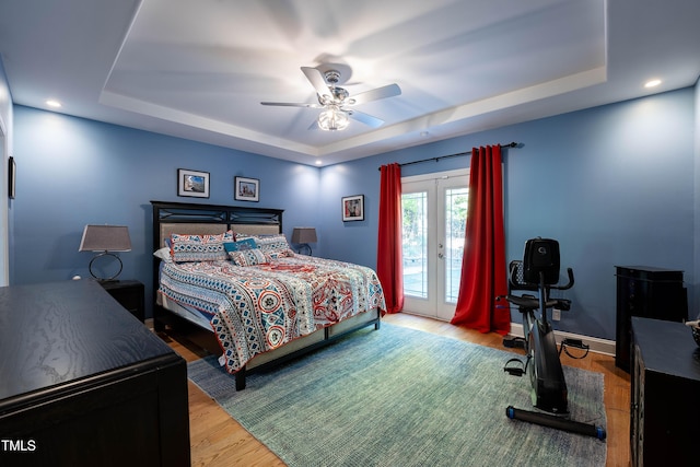 bedroom with a tray ceiling, access to outside, and french doors