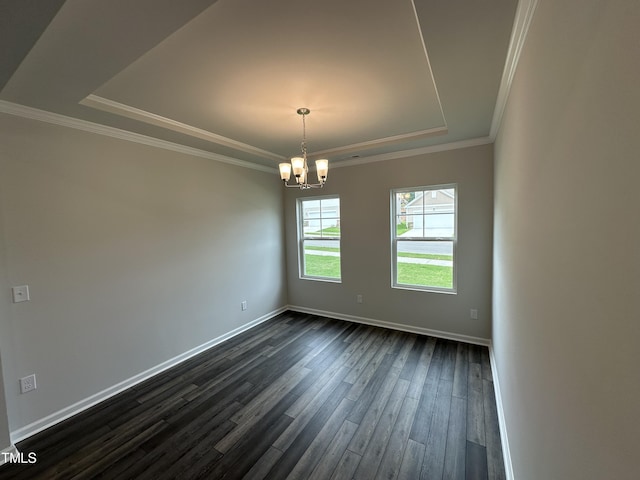 spare room featuring ornamental molding, dark wood-type flooring, an inviting chandelier, and a tray ceiling