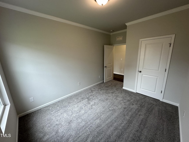 unfurnished bedroom featuring ornamental molding and dark carpet