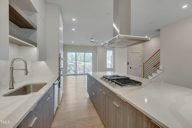 kitchen featuring gray cabinets, appliances with stainless steel finishes, sink, white cabinets, and island exhaust hood