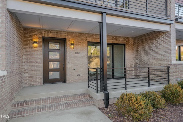 view of exterior entry featuring a balcony