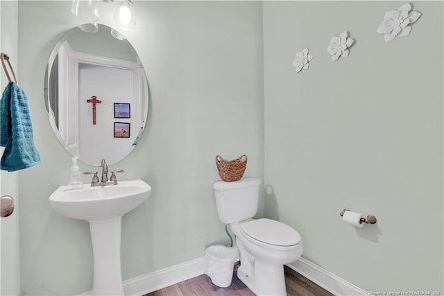 bathroom with wood-type flooring, toilet, and sink