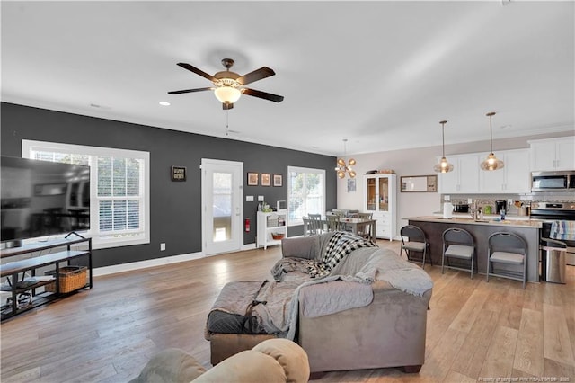 living room with ceiling fan and light wood-type flooring