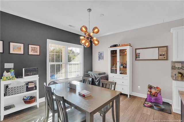 dining room featuring light hardwood / wood-style flooring and a notable chandelier