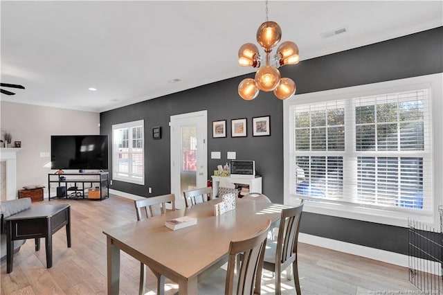 dining area featuring ceiling fan with notable chandelier and light hardwood / wood-style flooring