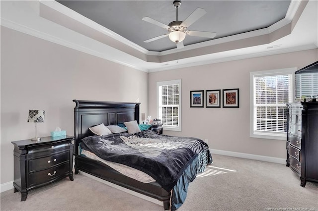 bedroom featuring crown molding, light carpet, ceiling fan, and a tray ceiling