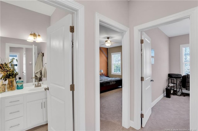 hallway featuring sink and light colored carpet