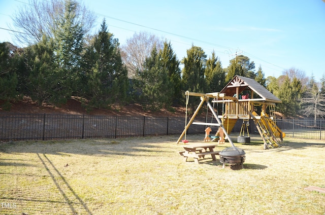 view of play area featuring an outdoor fire pit and a lawn