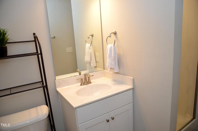 bathroom featuring vanity, an enclosed shower, and toilet